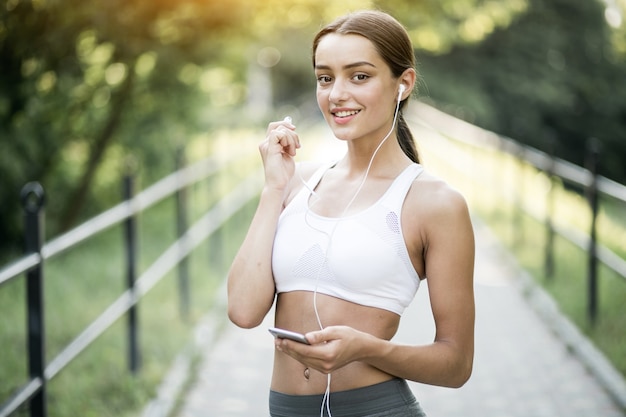 Contenedor jogging auriculares parque botella mujer