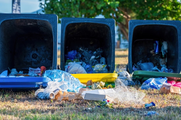 Contenedores caídos con basura caída en el suelo