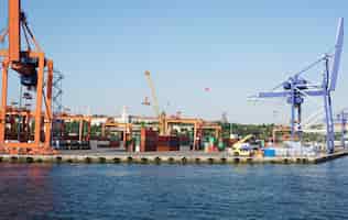 Foto gratuita contenedores de elevación con grúa en el puerto marítimo