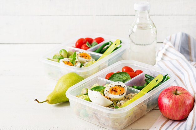 Contenedores de preparación de comida vegetariana con huevos, coles de Bruselas, judías verdes y tomate. Cena en fiambrera