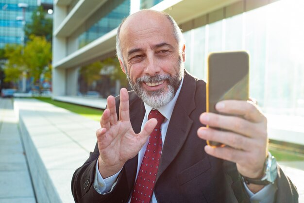 Contenido empresario agitando la mano durante el chat de video