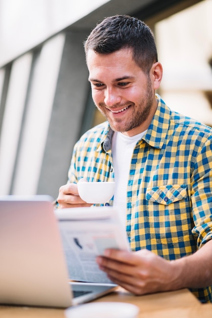 Contenido hombre disfrutando de periódico en la mañana