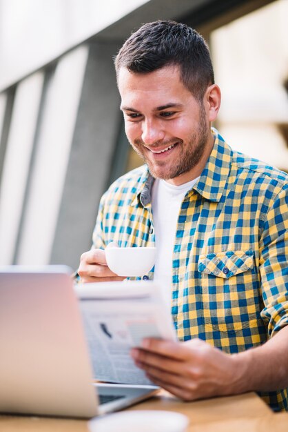 Contenido hombre disfrutando de periódico en la mañana