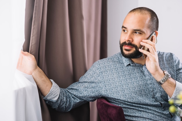 Foto gratuita contenido hombre hablando por teléfono en casa