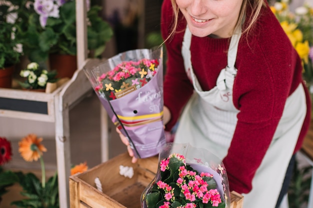 Foto gratuita contenido mujer arreglando flores entregadas