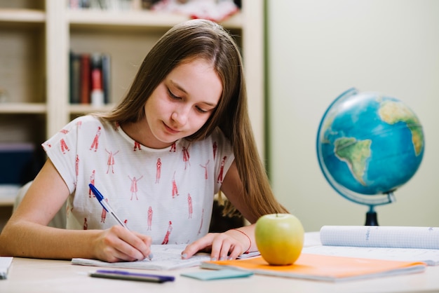 Foto gratuita content colegiala estudiando en la mesa