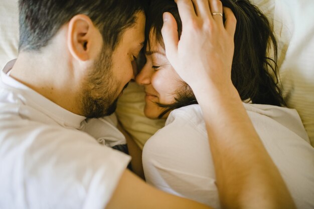 Contento marido y mujer abrazando en la cama