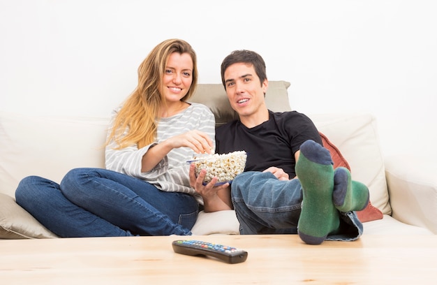 Foto gratuita control remoto frente a pareja comiendo palomitas