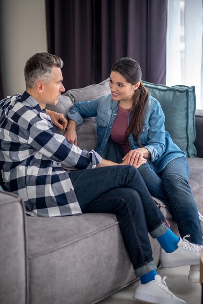 Conversación importante Hombre atento de lado a la cámara tocando a la mujer mirándose