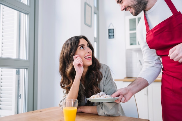 Cook hombre sirviendo croissant para mujer