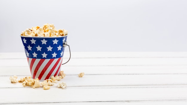 Foto gratuita copa con bandera americana y palomitas de maíz en superficie blanca