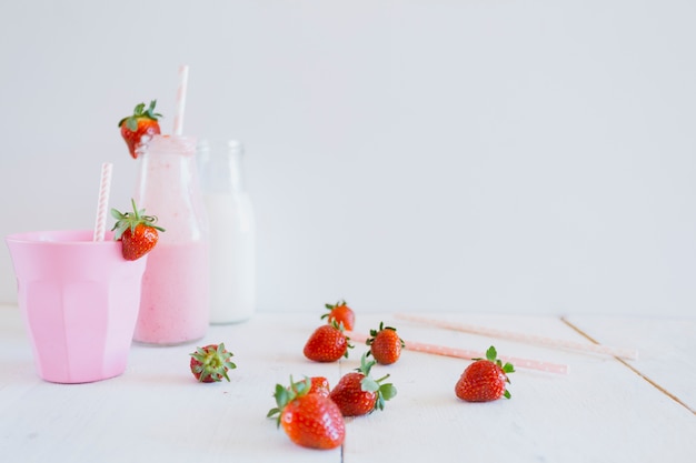 Copa cerca de botellas y fresas