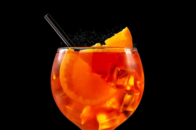 Copa de cóctel aperol spritz sobre fondo negro