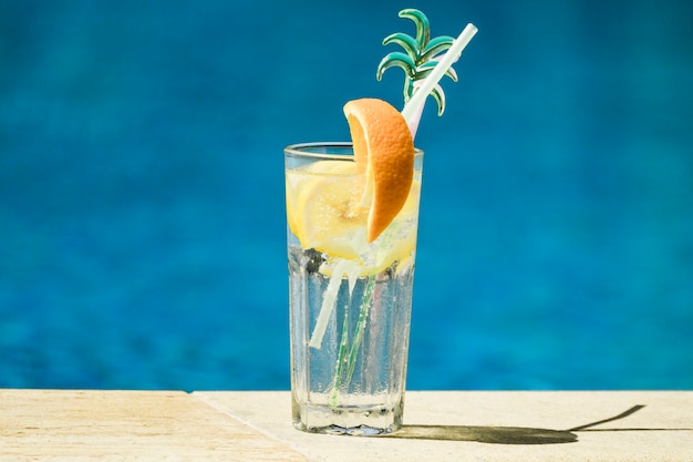 Foto gratuita copa de cóctel con limón y rodajas de naranja y pajitas