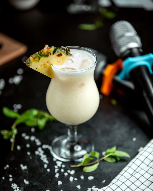 Una copa de cóctel de piña adornada con una rodaja de piña