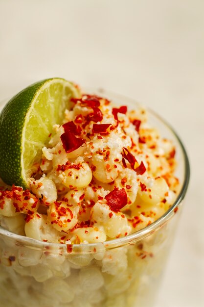 Copa con deliciosos esquites y limón alto ángulo