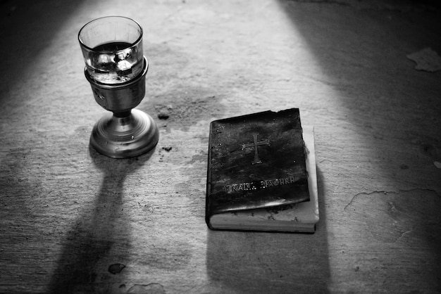 Copa y libro biblia en blanco y negro.