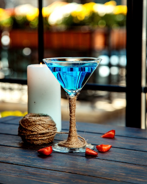Una copa de martini de laguna azul decorada con yute