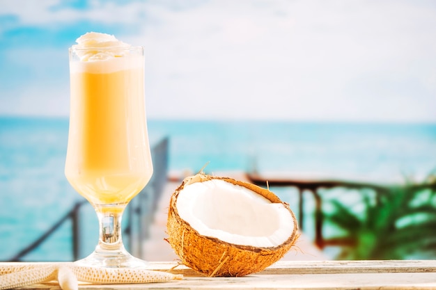 Foto gratuita copa de suave bebida amarilla de estrella de mar y coco agrietado