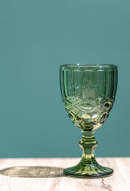Copa de vidrio con textura verde sobre un fondo azul.
