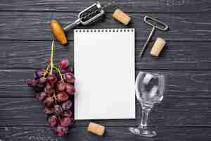 Foto gratuita copa de vino al lado del cuaderno en la mesa