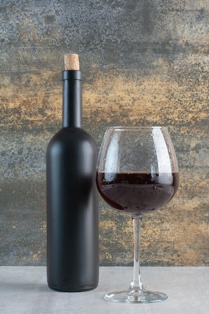 Una copa de vino con botella sobre fondo blanco. Foto de alta calidad