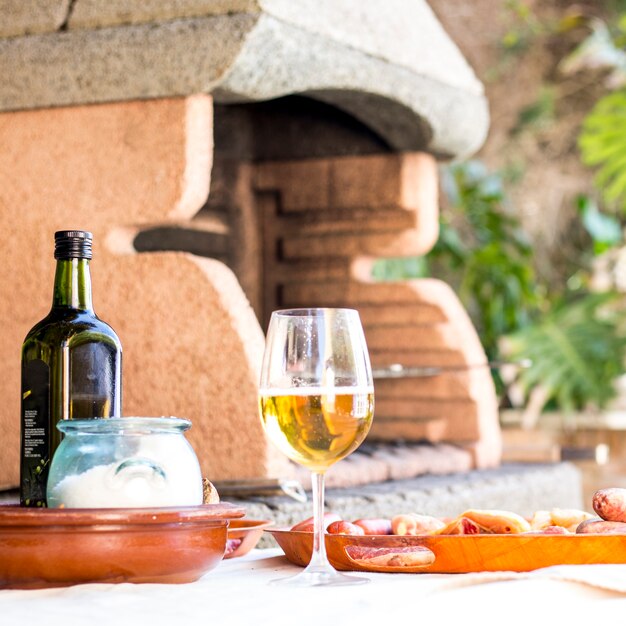 Copa de vino y comida a la parrilla servida en una mesa al aire libre
