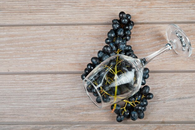 Una copa de vino y un racimo de uvas tintas.