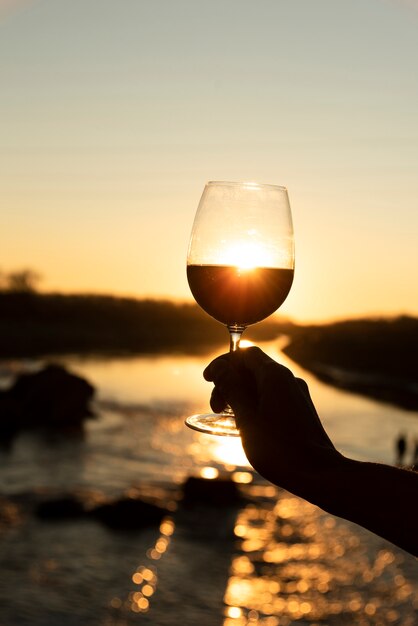 Copa de vino con sol brillando en la espalda