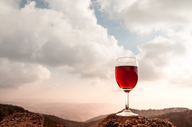 Copa de vino tinto y hermosa montaña de otoño