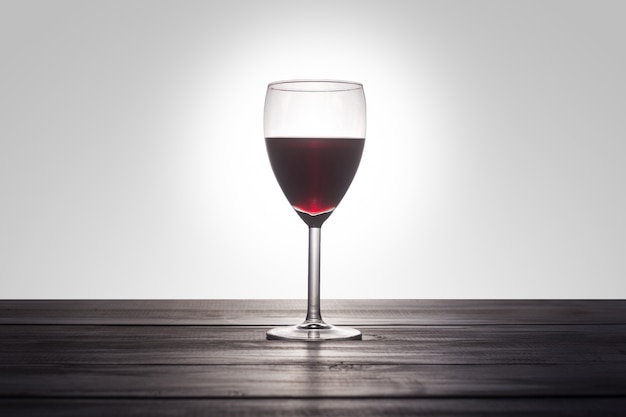 Una copa de vino tinto sobre una superficie de madera