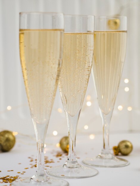 Copas de champagne con globos dorados y luces.