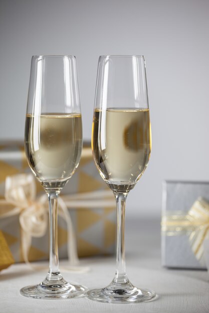 Copas con champagne y regalos de fondo