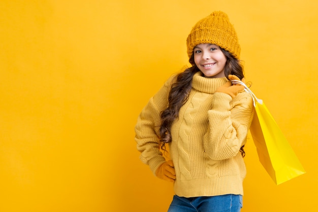 Foto gratuita copia espacio chica con bolsa de ropa de compras de invierno