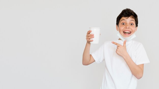 Copia-espacio chico apuntando a la taza de té