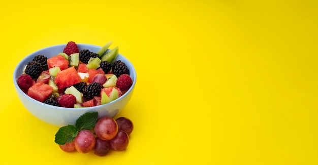 Copia espacio de fondo amarillo con ensalada de frutas