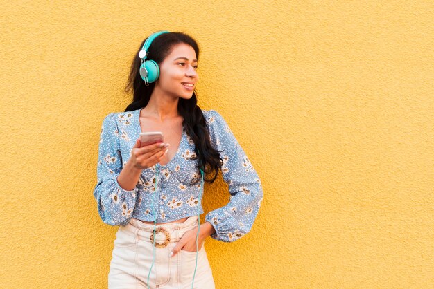 Copia espacio fondo amarillo con mujer y auriculares