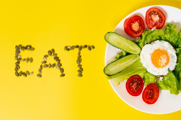 Foto gratuita copia espacio huevo con plato de verduras frescas sobre fondo liso