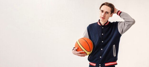 Copia espacio joven con pelota de baloncesto