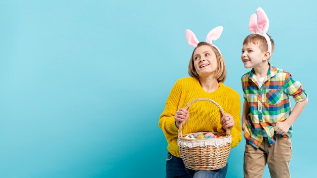 Copia espacio mamá con hijo sosteniendo huevos pintados preparados para pascua