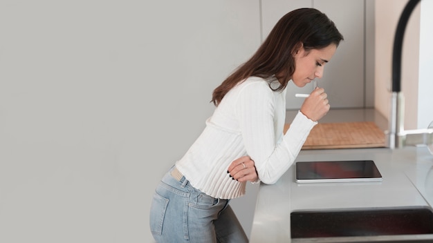 Copia espacio mujer en cocina con tableta