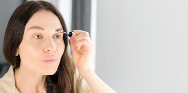 Copia espacio mujer haciendo cejas