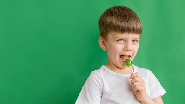 Copia-espacio niño comiendo piruleta