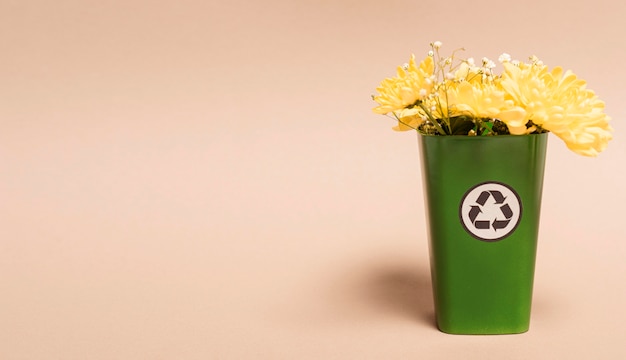 Copia espacio papelera de reciclaje con flores.