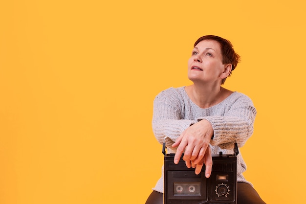 Copia espacio soñadora mujer senior con cassette