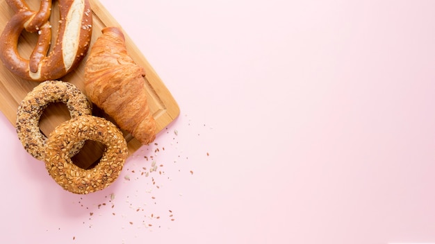 Copia-espacio tablero de madera con pretzel y croissant