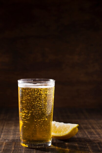 Copia espacio de vidrio con espuma de cerveza en la mesa