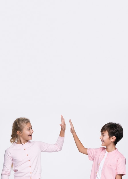 Foto gratuita copiar espacio jóvenes hermanos dando choca esos cinco