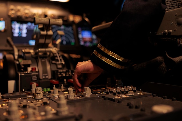 Foto gratuita copiloto femenino cambiando los botones del panel de control en el comando del tablero, usando la brújula de radar en el parabrisas en la cabina de la cabina. avión de pasajeros con navegación de viaje. de cerca.