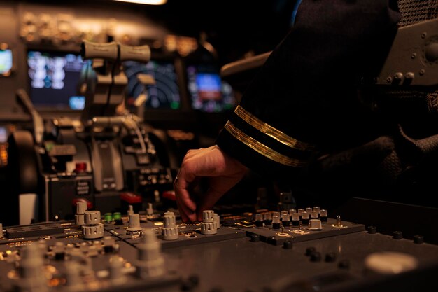 Copiloto femenino cambiando los botones del panel de control en el comando del tablero, usando la brújula de radar en el parabrisas en la cabina de la cabina. Avión de pasajeros con navegación de viaje. De cerca.